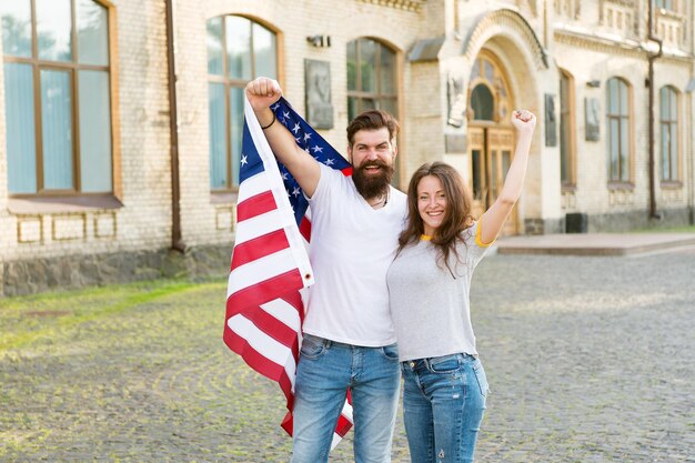 La cittadinanza americana è un bene prezioso Uomo barbuto e donna sensuale con bandiera americana il 4 luglio Coppia americana che celebra il giorno dell'Indipendenza Vivere il sogno americano