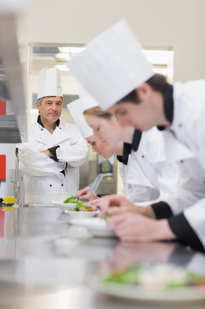 La classe culinaria prepara insalate mentre l&#39;insegnante sta supervisionando