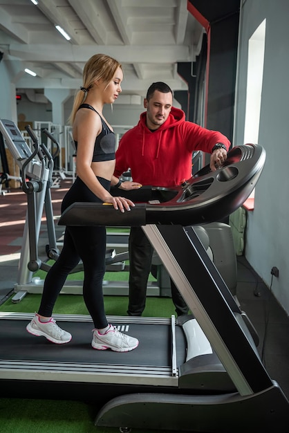 La cliente felice e stanca è grata al marito allenatore di fitness per gli allenamenti promettenti tempestivi e la buona forma fisica Il concetto di una cliente che è grata al marito allenatore