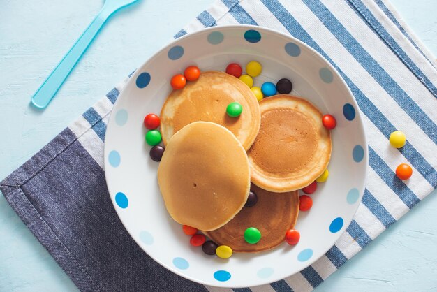 La colazione dei bambini o il dolce pancake con caramelle colorate