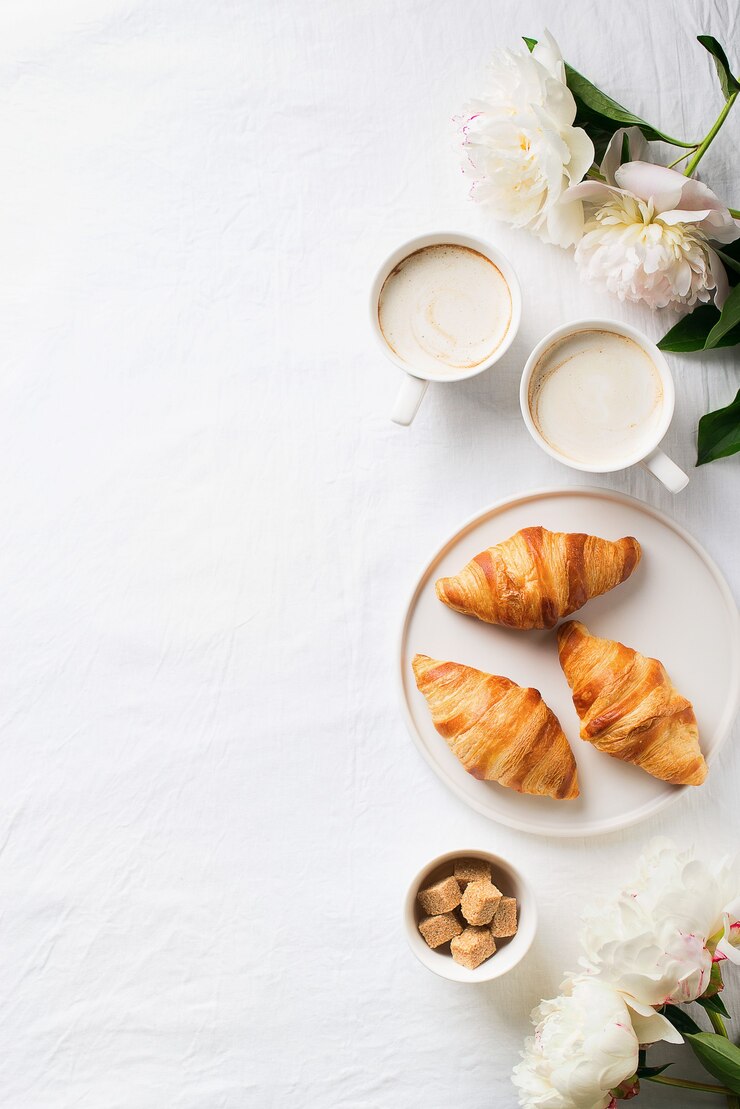 Foto la colazione sul piatto bianco laici. croissant con tazza di caffè e fiori