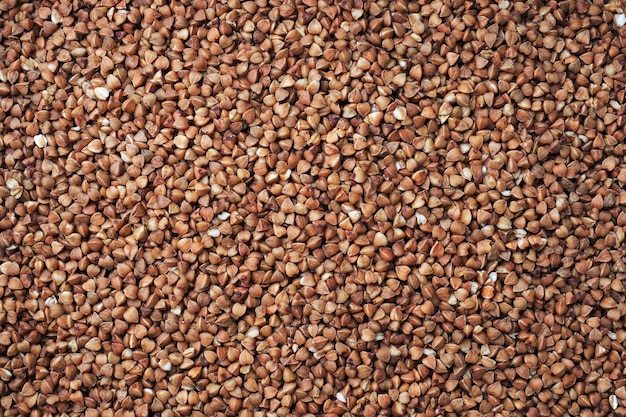 La consistenza dei chicchi di grano saraceno crudo. Marrone del grano saraceno dei cereali del fondo naturale. Avvicinamento.