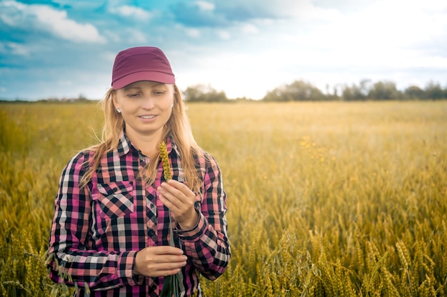 La contadina esamina le spighe di grano nel campo