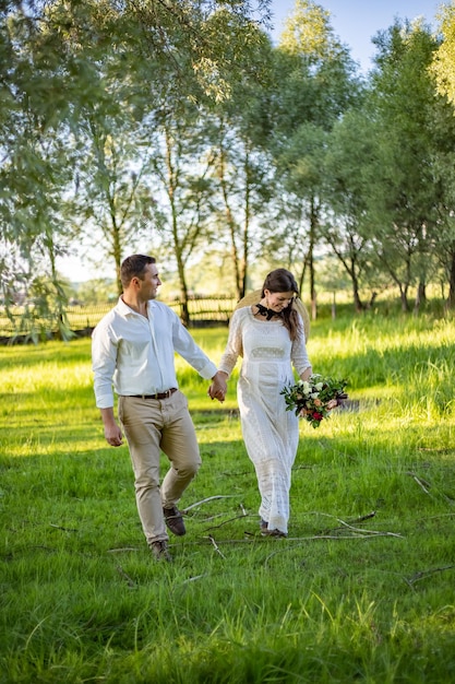 La coppia attraversa il campo Si tengono in mano Il velo si dissolve Nelle mani di un bouquet