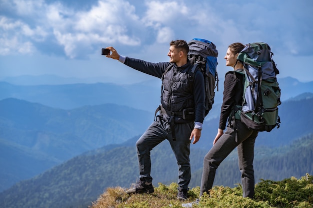 La coppia con gli zaini si fa un selfie sulla scogliera