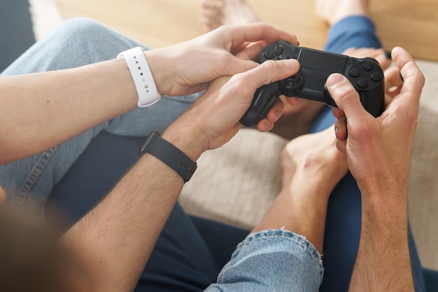 La coppia con un gamepad sta giocando a una console per videogiochi a casa