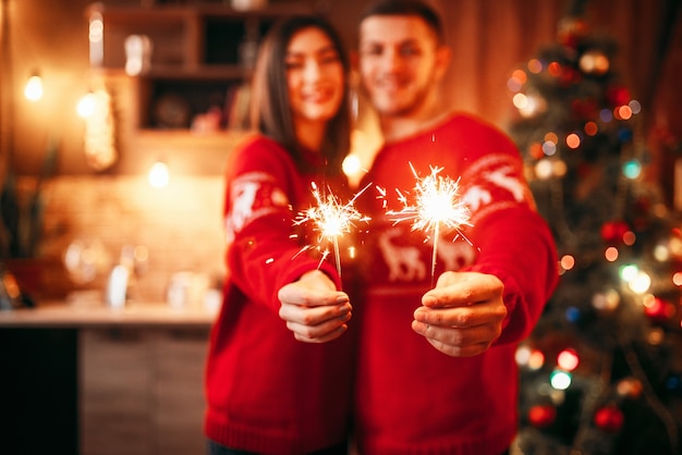 La coppia di amore tiene le stelle filanti nelle mani, natale