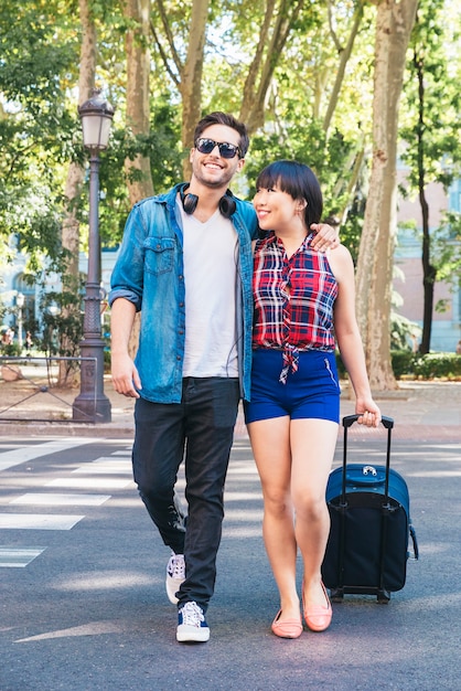 La coppia di turisti ama camminare in città con la valigia