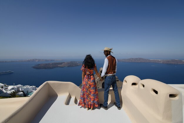La coppia è seduta sul tetto a Santorini, abbracciata e ridendo