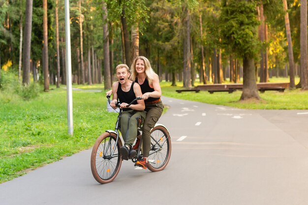 La coppia felice in bici nel parco