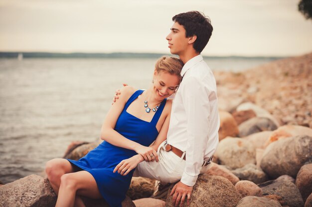 La coppia felice si siede su una roccia