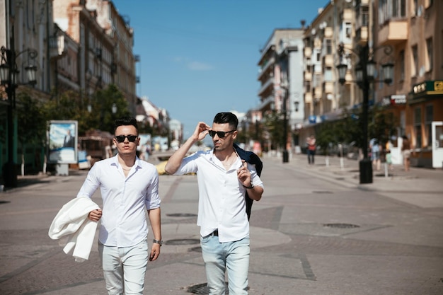 La coppia gay asiatica sta camminando per strada guardando i luoghi che si divertono insieme Ben vestiti di moda