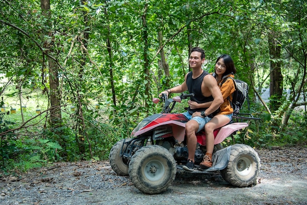 La coppia guida l'ATV attraversando la foresta con gioia ed eccitazione