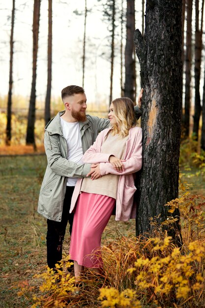 La coppia nell'amore cammina attraverso la foresta di autunno