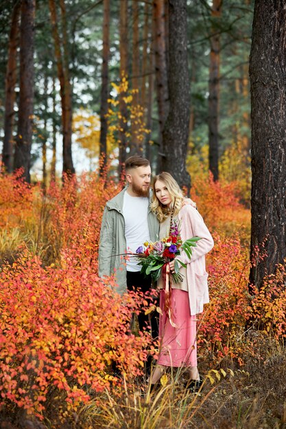 La coppia nell'amore cammina attraverso la foresta di autunno.