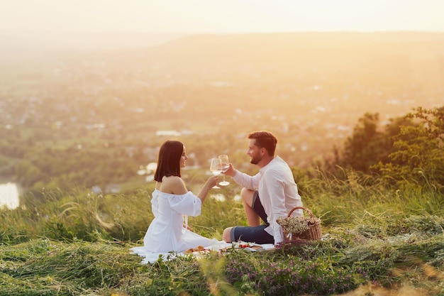 la coppia si sta godendo il picnic al tramonto