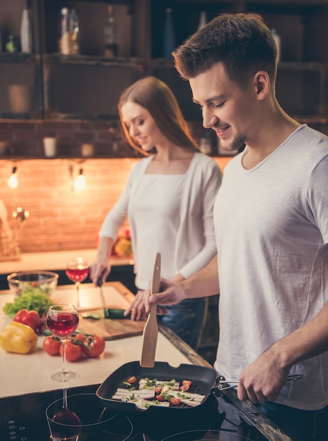 La coppia sta sorridendo mentre cucinava insieme nella cucina