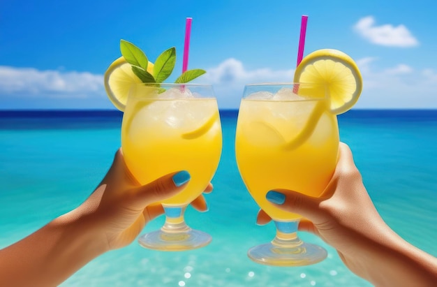 La coppia tiene in mano cocktail colorati sullo sfondo del mare