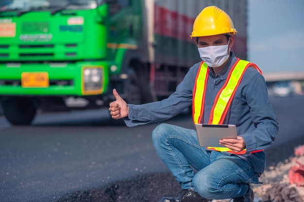 La costruzione di ingegneri asiatici è un lavoratore dipendente che lavora con un casco di controllo di sicurezza in loco