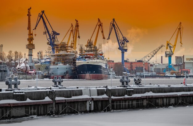 La costruzione di rompighiaccio nucleari alle magiche gru al tramonto del cantiere navale baltico in un gelido...