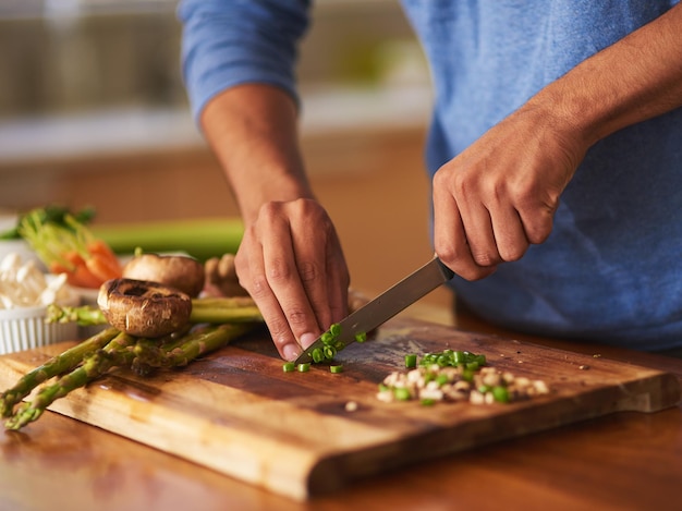 La cottura è un gradino sopra il resto. Colpo ritagliato di un uomo che prepara un pasto sano a casa.