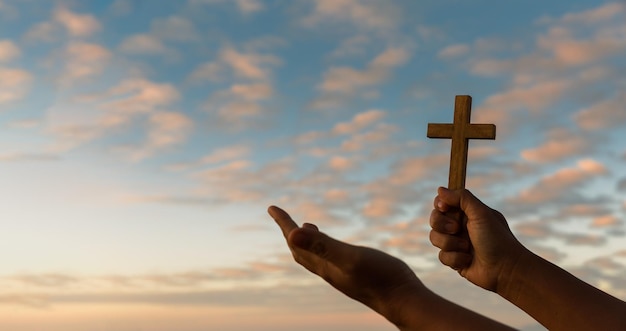 La croce è un simbolo del cristianesimo Le mani umane aprono il palmo verso l'alto adorando l'Eucaristia