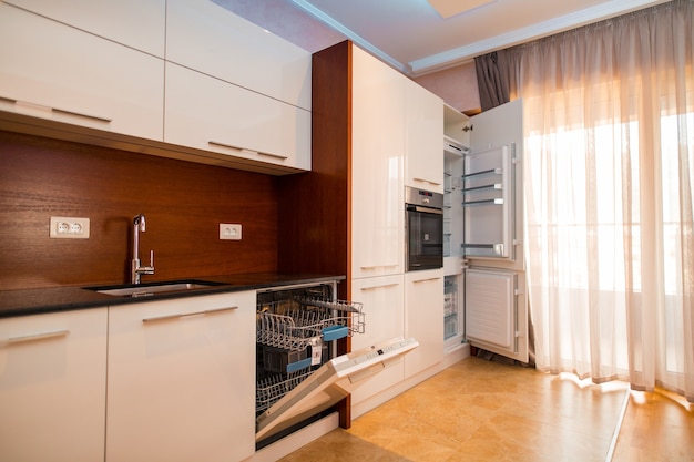 La cucina dell'appartamento. Il design della cucina. Cucina in legno, frigorifero, piano cottura, tavolo da pranzo. Cucina interna.