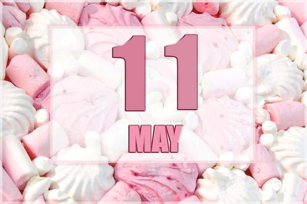 La data del calendario sullo sfondo dei marshmallow bianchi e rosa L'11 maggio è l'undicesimo giorno del mese