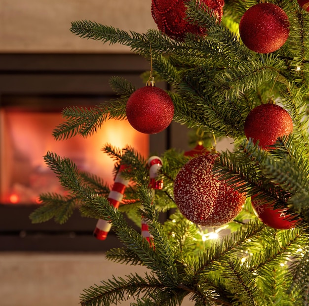 La decorazione dell'albero di Natale e le luci si chiudono sulla vista che brucia sullo sfondo del camino