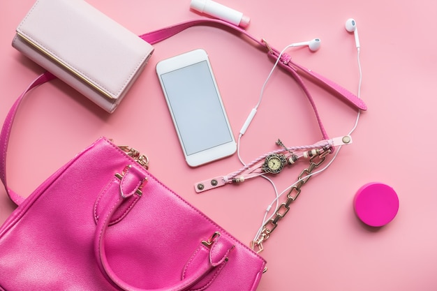 La distesa piatta della borsa da donna rosa si apre con gli accessori