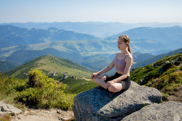 La donna a praticare yoga in montagna