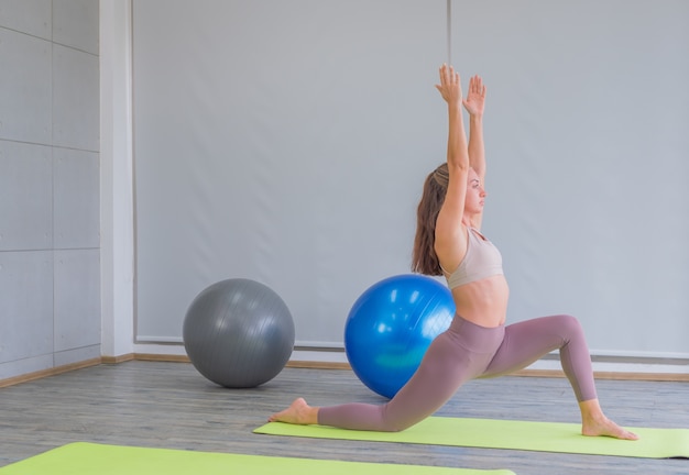 La donna a praticare yoga in palestra