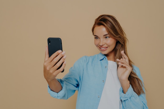 La donna abbastanza giovane fa il selfie con lo smart phone