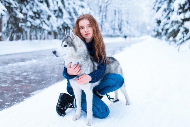 La donna abbraccia con il husky siberiano