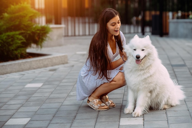 La donna abbraccia un grosso cane al tramonto