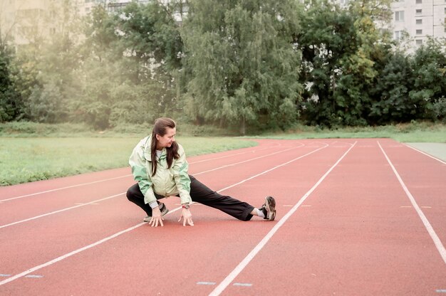 la donna adulta è impegnata nello stretching in uno stadio all'aperto