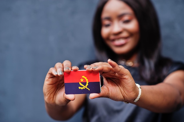 La donna africana tiene in mano una piccola bandiera dell'Angola.