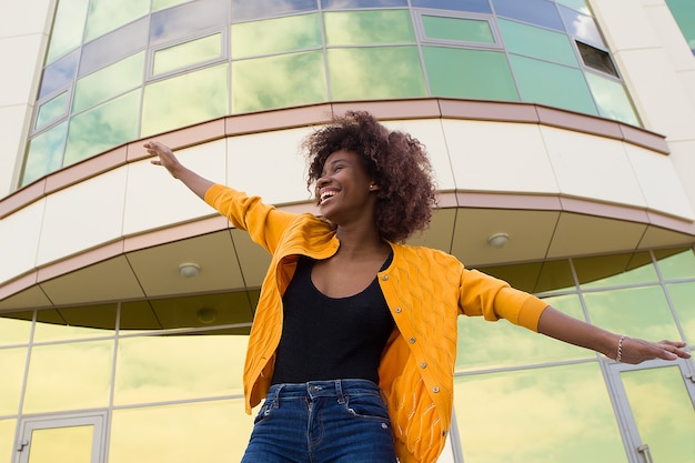 La donna afroamericana felice e giovane sulla strada divertendosi