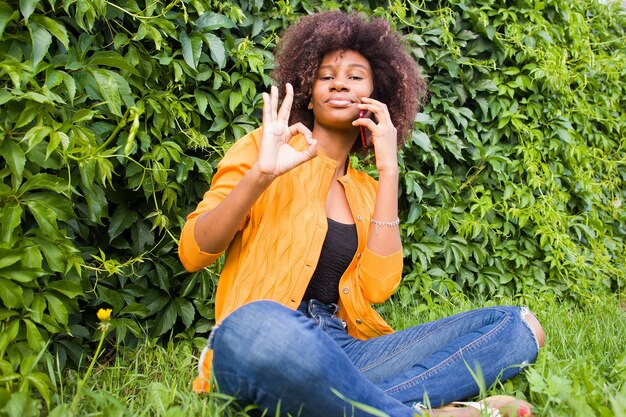 La donna afroamericana felice per strada a parlare al telefono