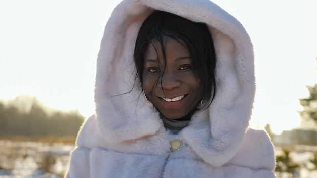 La donna afroamericana posa sorridente al servizio fotografico in inverno