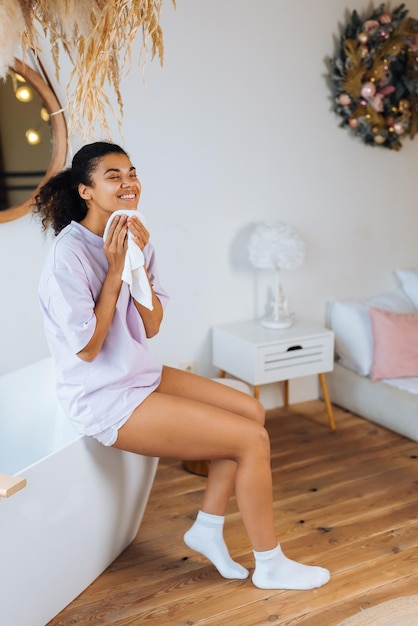 La donna afroamericana si prende cura della sua pelle in bagno