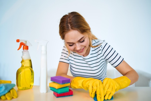 La donna al tavolo fornisce il servizio di igiene dei lavori domestici di lavaggio