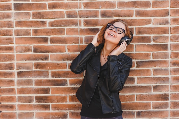 La donna allegra di Blondhair gode della musica in grandi cuffie