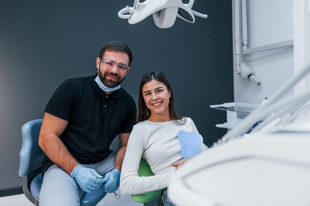 La donna allegra ha una visita nella clinica del dentista. Concezione della stomatologia.