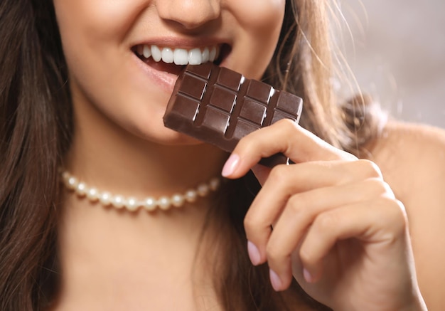 La donna amante del cioccolato morde il bar per godersi il sapore da vicino.
