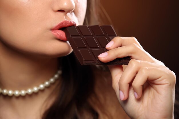 La donna amante del cioccolato morde il bar per godersi il sapore da vicino.