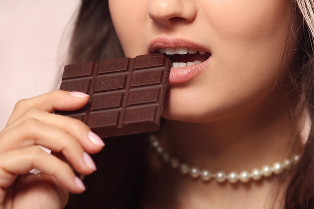 La donna amante del cioccolato morde il bar per godersi il sapore da vicino.