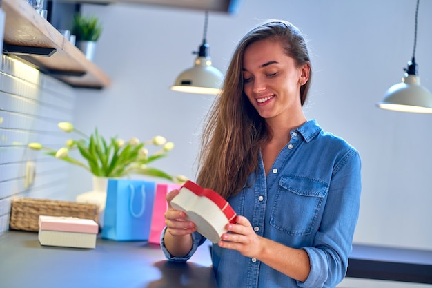 La donna amata felice sorridente gioiosa soddisfatta ha ricevuto una confezione regalo per un giorno di vacanze