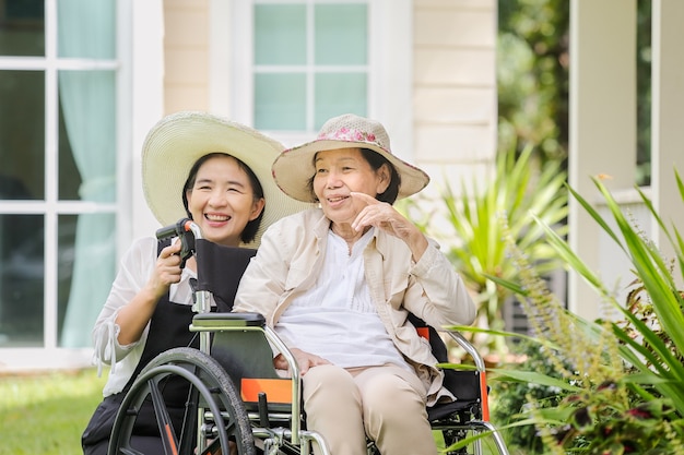 La donna anziana si rilassa sulla sedia a rotelle in cortile con la figlia