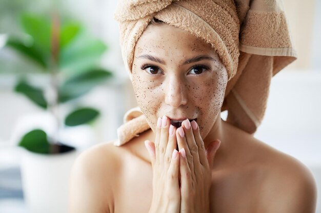 La donna applica lo scrub al caffè sul viso.